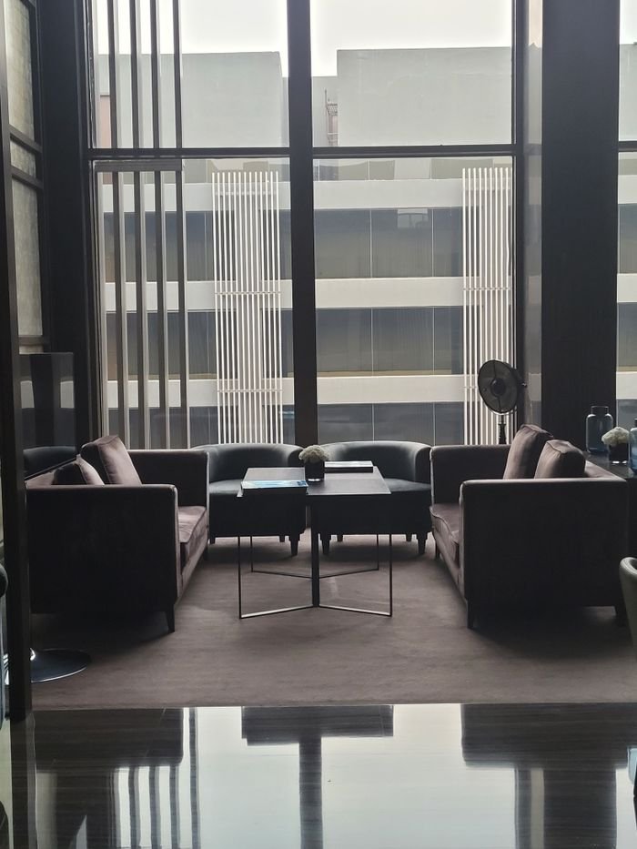 A stylish and modern interior lounge area with large windows and elegant furniture.